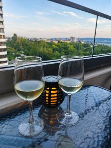 two glasses of white wine sitting on a table at Pool View Apartment Varna in Varna City