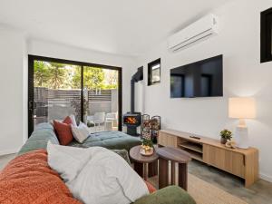 a living room with a couch and a tv at Stone River Villa 2 - Private Escape - Heated Pool in Margaret River Town