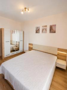 a bedroom with a large white bed and a mirror at Pool View Apartment Varna in Varna City +15 photos