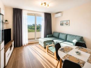 a living room with a couch and a table at Pool View Apartment Varna in Varna City