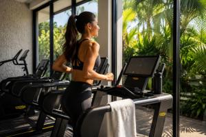 a woman running on a treadmill in a gym at Olivia Oceanfront Tulum in Tulum