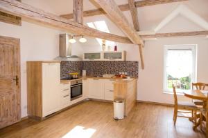 a kitchen with white cabinets and a wooden floor at Villa Cujez with Pool & Sauna - Happy Rentals in Rečica ob Savinji