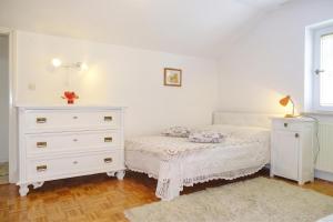 a white bedroom with a bed and a dresser at Villa Cujez with Pool & Sauna - Happy Rentals in Rečica ob Savinji