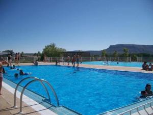 a large swimming pool with people in the water at Posada Real de Carreteros in Casarejos