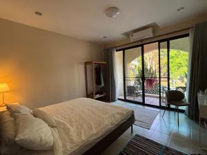 a bedroom with a bed and a sliding glass door at Clock Tower Apartments Chroma Pulse in Pai