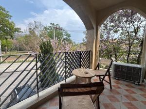 a porch with a table and chairs on a balcony at Clock Tower Apartments Chroma Pulse in Pai