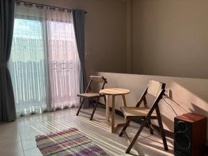 two chairs and a table in a room with a window at Clock Tower Apartments Chroma Pulse in Pai