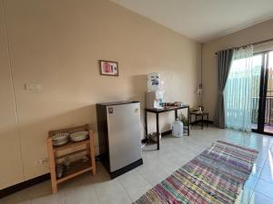 a kitchen with a refrigerator and a table at Clock Tower Apartments Chroma Pulse in Pai