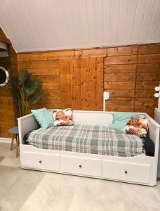 a white bed in a room with wooden walls at Le Chalet Spa Piscine in Rimbach-près-Masevaux