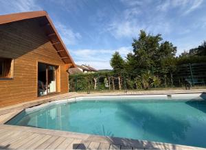 a swimming pool in front of a house at Le Chalet Spa Piscine in Rimbach-près-Masevaux