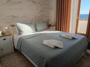 a bedroom with a bed with two towels on it at ELEVER Apartments in Agia Marina