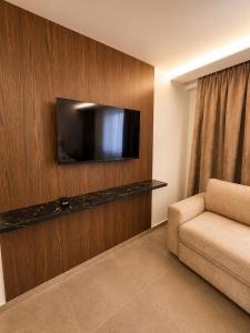 a living room with a couch and a flat screen tv at Bedo Boutique Hotel in Golem