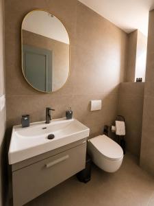 a bathroom with a sink and a toilet and a mirror at Bedo Boutique Hotel in Golem