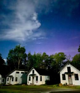 a house at night with stars in the sky at The Evergreen | Walk to Rangeley Lake, Sled & ATV Access in Rangeley