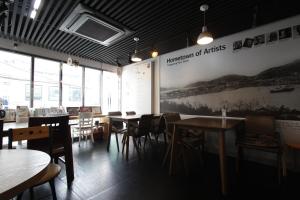 a restaurant with tables and chairs and a sign on the wall at Friend of Loft in T'ongyŏng