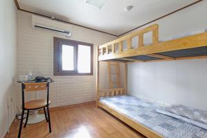 a room with two bunk beds and a chair at Friend of Loft in T'ongyŏng
