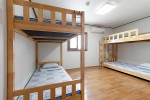 a room with two bunk beds and a window at Friend of Loft in T'ongyŏng