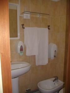 La salle de bains est pourvue d'un lavabo, de toilettes et de serviettes. dans l'établissement Pensione Aurora, à Imperia