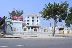 a white building with a sign in front of it at VGN Convention Centre in Vāniyambādi