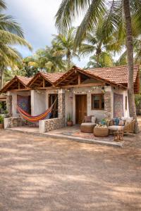 a house with a hammock in front of it at Salty Mango Resort in Kalpitiya
