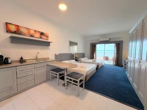 a kitchen and a living room with a bed and a couch at Rainbow Paradise Seaview by Achlys Collection in Tanjung Bungah