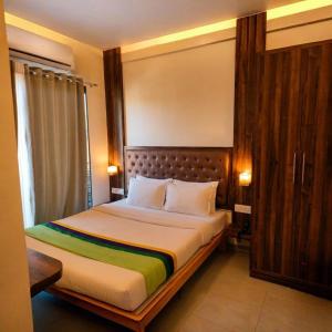 a bedroom with a bed with a wooden headboard at Green Woods Cottage by JN in Mahabaleshwar