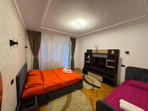 a small room with a bed and a tv at Linen Tree Apartment in Băile Herculane
