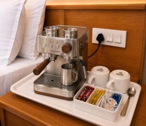 a coffee maker on a tray next to a bed at Marawi Desert Resort in Sām