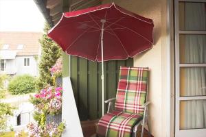 a chair and an umbrella on a porch at Aparthotel Alter Weißbräu in Bad Birnbach