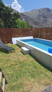 a swimming pool in a yard next to a brick wall at Villa Doña Isabel in Lunahuaná