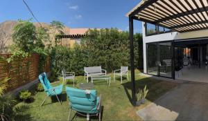 a patio with chairs and tables in a yard at Villa Doña Isabel in Lunahuaná