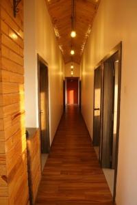 a long hallway with wooden floors and doors at Green Woods Cottage by JN in Mahabaleshwar