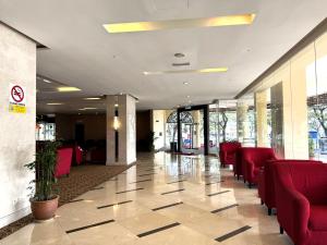 a lobby with red chairs in a building at Pearl View Hotel Prai, Penang in Perai