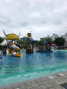 a swimming pool with a water park at Aju Good House 아주굿하우스 in Geoje
