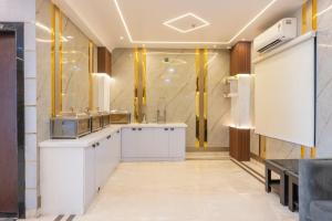 a kitchen with white cabinets and yellow accents at Hotel Maharani Palace in Varanasi +53 photos