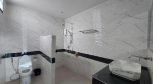 a white bathroom with a toilet and a sink at A Day Hotel in Roi Et +52 photos