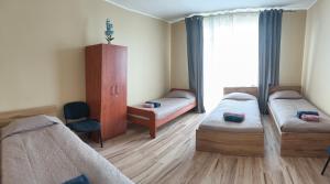 a room with three beds and a window at Babilonas in Plungė