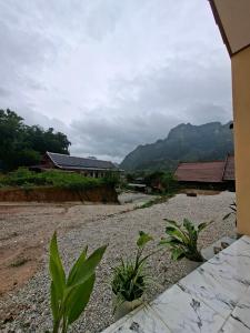 a view of a house with mountains in the background at Sokmoungkhoun in Nongkhiaw