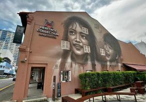 a building with a large painting of a woman on it at Heritage Collection on Victoria - Mobile App Check-In in Singapore