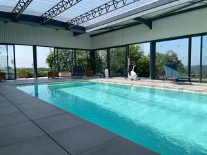 a large swimming pool with a dog sitting next to it at Le Coquelicot in Najac