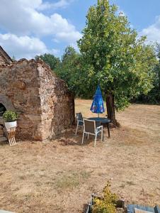 a table with a blue umbrella and two chairs at Le Coquelicot in Najac +6 photos