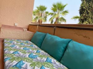 a bed with blue pillows in a room with palm trees at Casa Corner- Bonito Apartamento con mini piscina en Hacienda del Alamo in Escobar +19 photos
