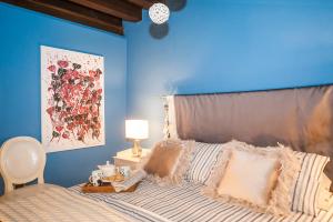 een slaapkamer met een bed met een blauwe muur bij Casa Torrazzo in Pisogne
