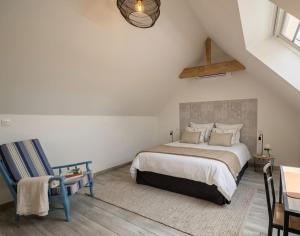 a bedroom with a bed and a table and a chair at LE CHARME D OGNES in Ognes
