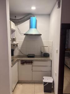 a kitchen with a blue light hanging over a counter at Rabbit Stays apartment in Zirakpur