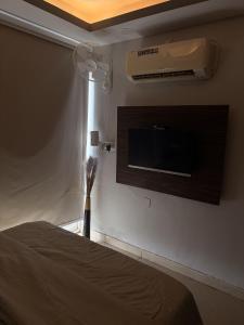 a bedroom with a tv on the wall and a bed at Rabbit Stays apartment in Zirakpur