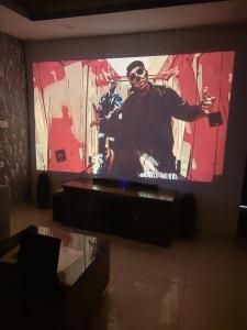 a flat screen tv with a man on it at Rabbit Stays apartment in Zirakpur