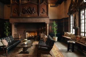 a living room with a fireplace and black leather furniture at Chicago Athletic Association, part of Hyatt in Chicago