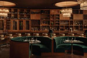 a restaurant with two tables and green chairs at Chicago Athletic Association, part of Hyatt in Chicago +70 photos