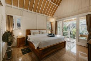 a bedroom with a bed and a large window at Jalana Palm Villa in Tabanan +31 photos